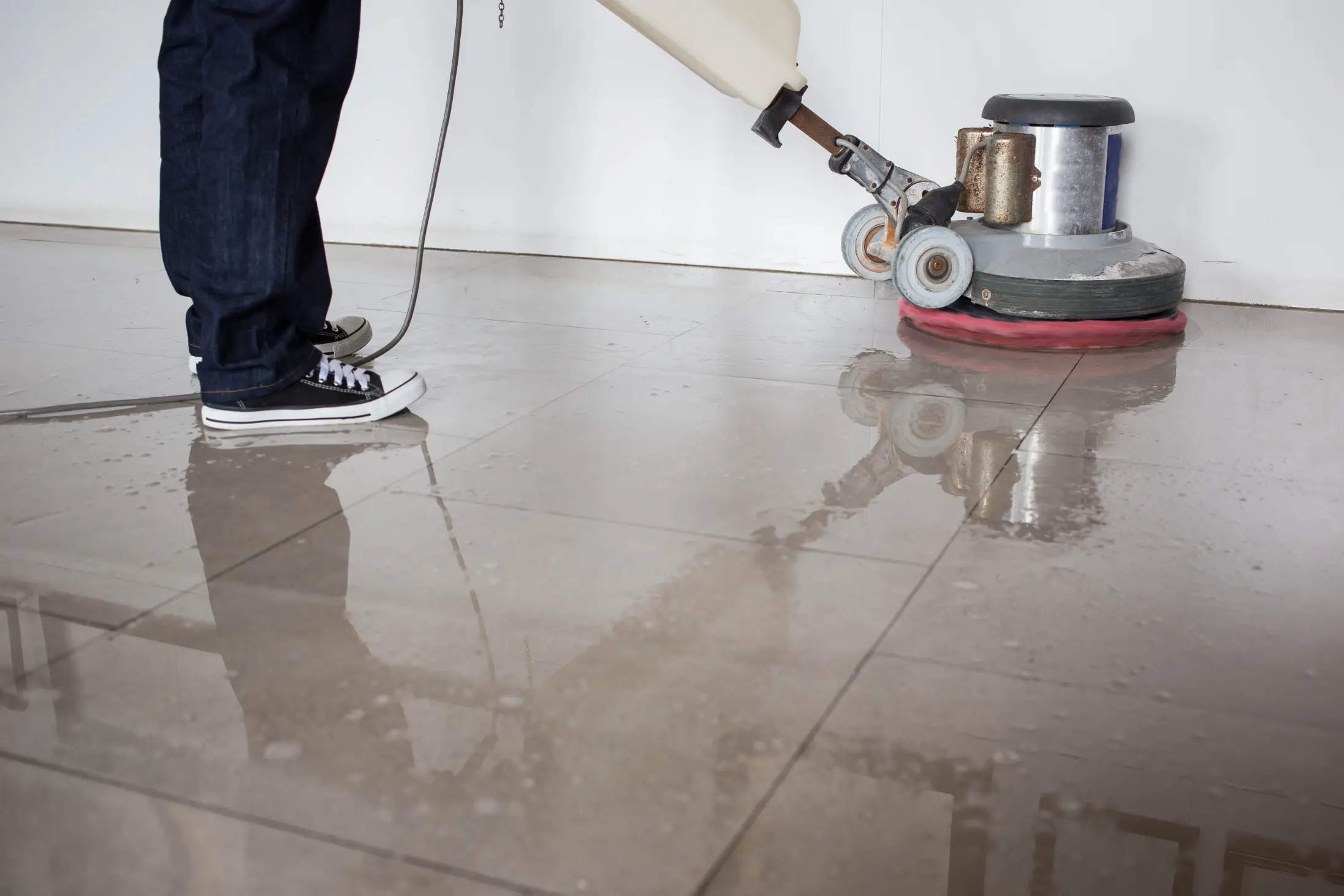 Person vacuuming tile floors during professional floor cleaning